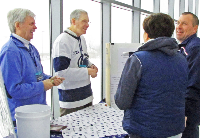 Volunteers running the club table on the concourse at a home game
